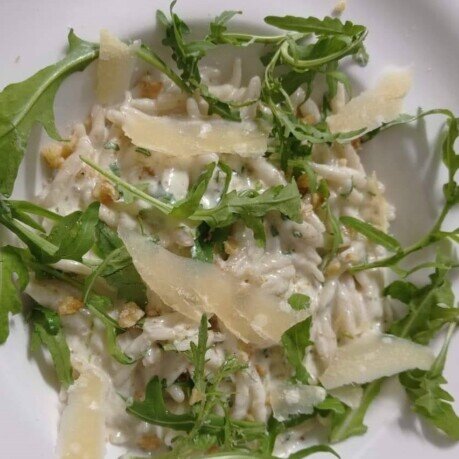 Trofiette Liguri in salsa di noci con rucola e scaglie di formaggio grana Trofie liguri in salsa di rucola e noci guarnite con rucola e scaglie di grana padano